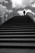 man walking over a stairway in a train station