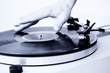 Man's hand spinning a vinyl record. 