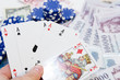 Poker hands - cards have focus with poker chips and money