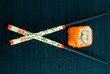 Sushi with chopsticks shot on black