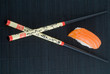 Sushi with chopsticks shot on black