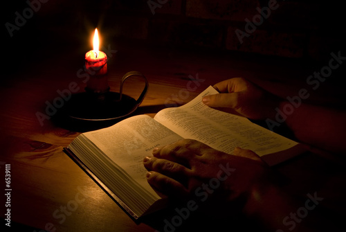 Photo: Reading the bible by candle light Reading the bible by candle light