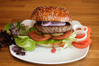 Hamburger on a plate with greens