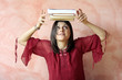 ragazza con 4 libri appoggiati sulla testa