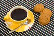 Cookies and cup with cofee on bamboo table-cloth