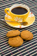 Cookies and cup with cofee on bamboo table-cloth