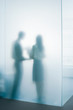 Two people behind frosted glass