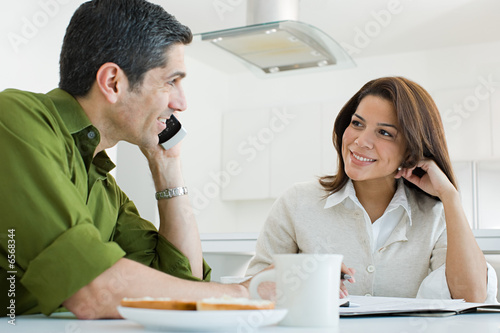 Man using cellular telephone at breakfast