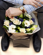 Business man with flowers checking watch