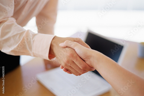 Handshake across a desk Handshake across a desk
