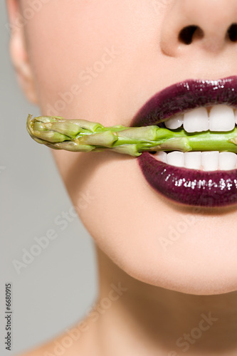 Woman with asparagus in her mouth