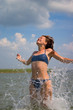 girl jumping in water with splashes