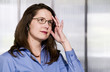 Woman in an Office Touches Her Head