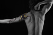 Artistic portrait of young male back with bodypaint drawing