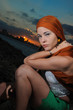 Fashion model sitting outdoors at sunset 