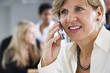 A smiling business woman using a cellphone.