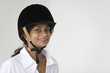 Portrait of cheerful woman wearing an equestrian hard hat.