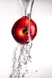 water pouring over apple on white