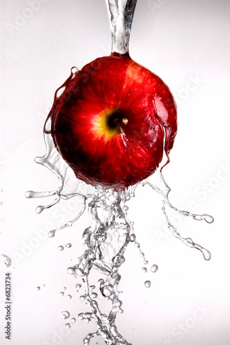 Photo: water pouring over apple on white water pouring over apple on white