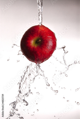Photo: water pouring over red apple water pouring over red apple