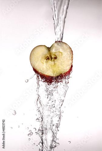 Photo: Apple with water pouring over it on white Apple with water pouring over it on white