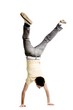 Young adult male doing a handstand on a white background