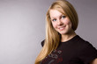 A smiling blonde on a grey background in studio. A smiling blonde on a grey background in studio.