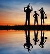 family silhouette on sunset sky. water family silhouette on sunset sky. water
