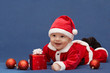 baby in santa's suit with gift and christmas balls baby in santa's suit with gift and christmas balls