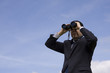 Businessman looking through binoculars