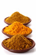 piles of bright Curry Powder and tumeric in teracotta dish piles of bright Curry Powder and tumeric in teracotta dish