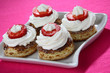 Cookies with jam, white cream and cut fresh strawberries