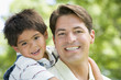 Photo: Hispanic father giving son piggy back Hispanic father giving son piggy back