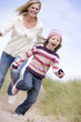 Mother chasing daughter through sand dunes