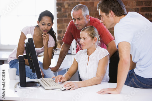 Photo: Group of business people working around computer Group of business people working around computer