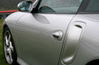 side of silver performance car at the race track