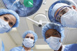 Four surgeons looking down, low angle view