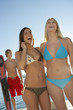 Two young women in swimwear at lake, laughing