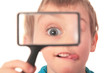 boy looks through  magnifier with interest