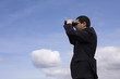Businessman looking through binoculars