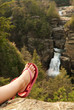 A human foot relaxing in front of waterfall.