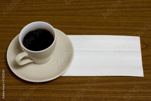 Foto: A cup of coffee with napkin on a table A cup of coffee with napkin on a table