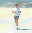 Photo: Senior man running in the sun at the beach Senior man running in the sun at the beach