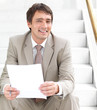 Businessman sitting on stairs with paperwork