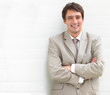 Young attractive business man standing against white wall
