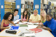 Photo: Group of university students working in library Group of university students working in library