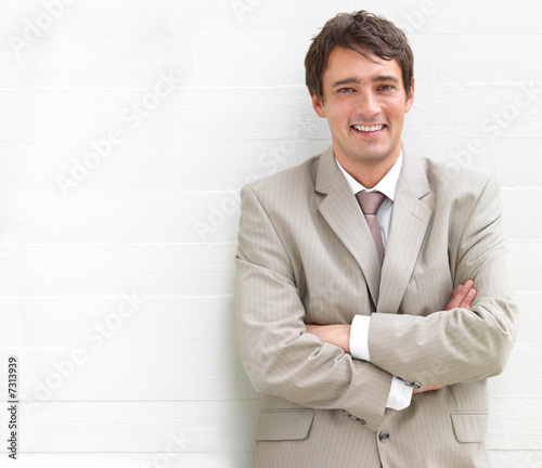 Young attractive business man standing against white wall