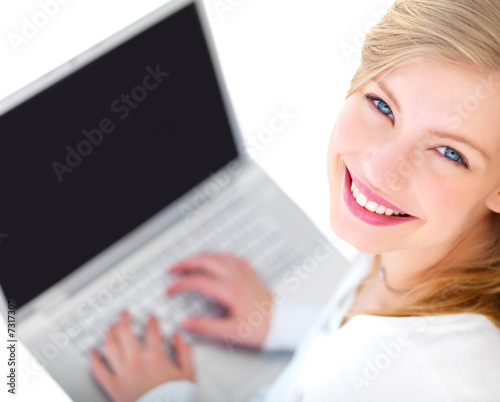 Photo: Young smiling teenager working on laptop Young smiling teenager working on laptop