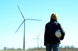Woman engineer or architect with white safety hat and wind turbi