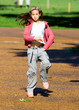 A young girl having fun in the park,dancing in the sunshine.